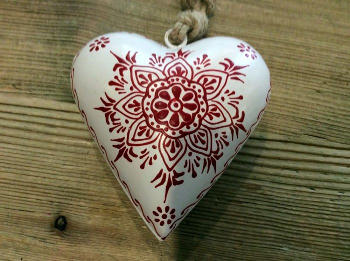 Coeur blanc bombé et décoré d'arabesques rouges, métal