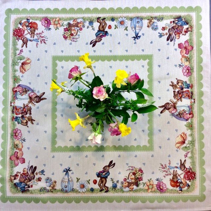 Nappe de Pâques fleurie, famille lapins et oeufs, frise vert anis, centrée sur fond beige, carrée 100x100 cm, polycoton jacquard