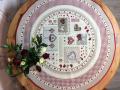 Nappe Patchwork bordurée Vichy rouge, coeurs et carreaux, centrée sur fond beige, ronde Ø 90 cm, polycoton jacquard
