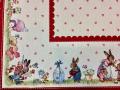 Nappe de Pâques fleurie, famille lapins et oeufs, frise bordeaux, centrée sur fond beige, rectangulaire 140x240 cm, polycoton jacquard