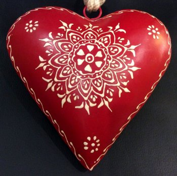 Coeur rouge bombé et décoré d'arabesques blancs, métal