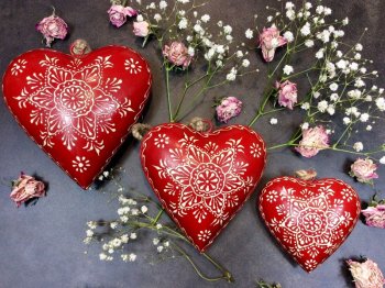 Coeur bombé rouge, décoré d'arabesques blancs, métal 